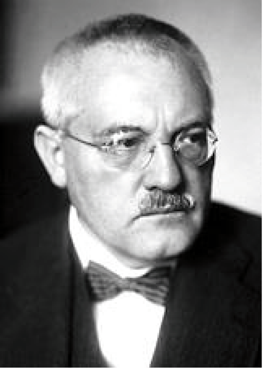 Schwarz-weiß Porträt eines Mannes mit Brille und Fliege, der ernst in die Kamera schaut.