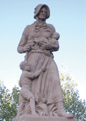 Statue einer Frau mit zwei Kindern, die Natur umgibt.