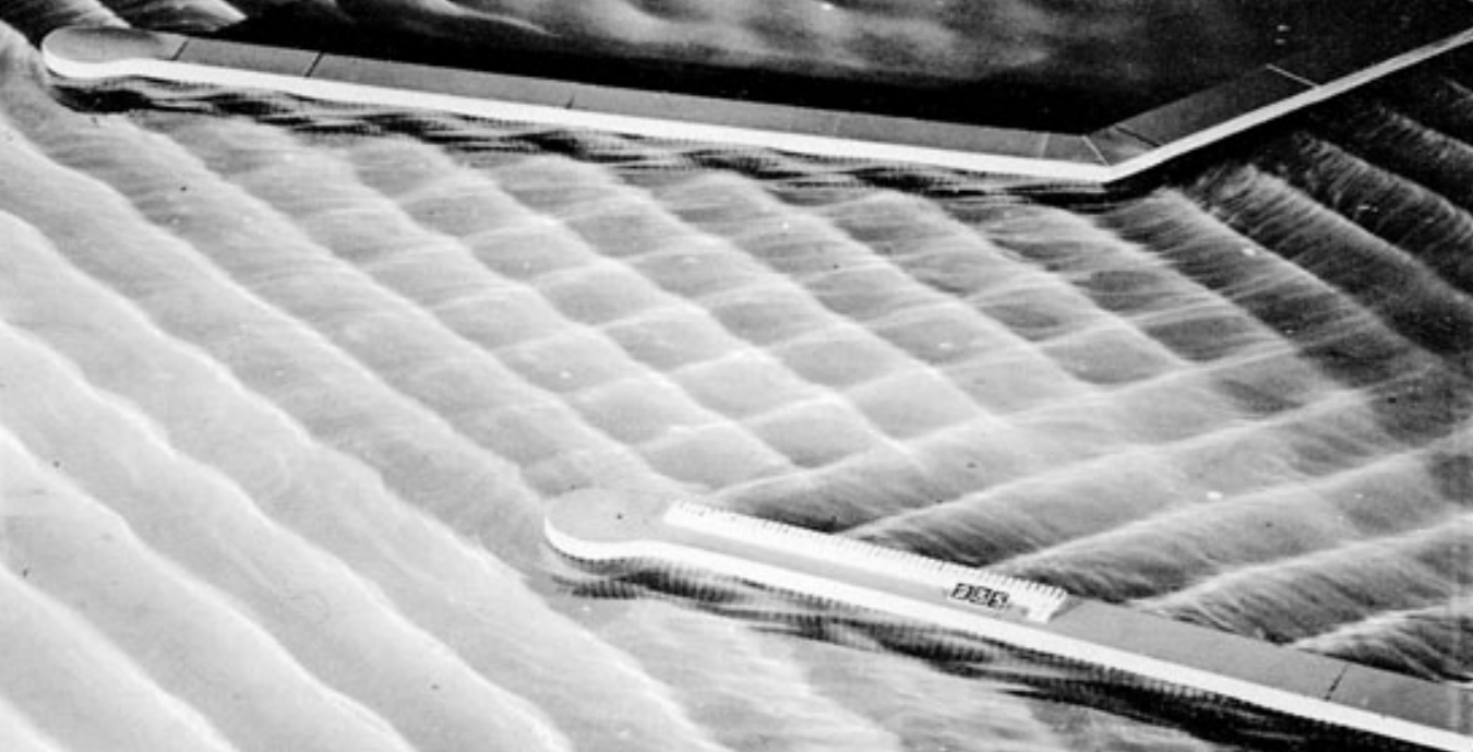 Wasseroberfläche mit regelmäßigen Wellenmustern und zwei länglichen Messbalken