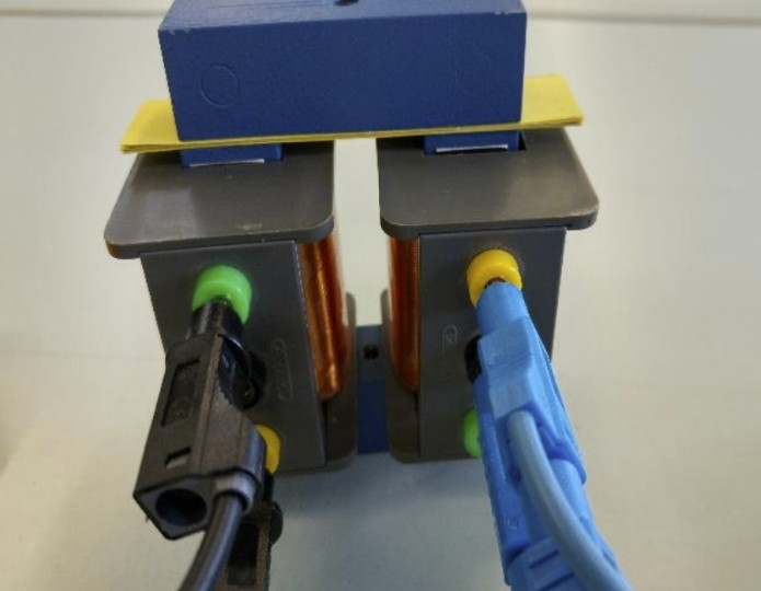 Elektrischer Aufbau: zwei Spulen nebeneinander, gelbe Stecker und angeschlossene schwarze und blaue Kabel.