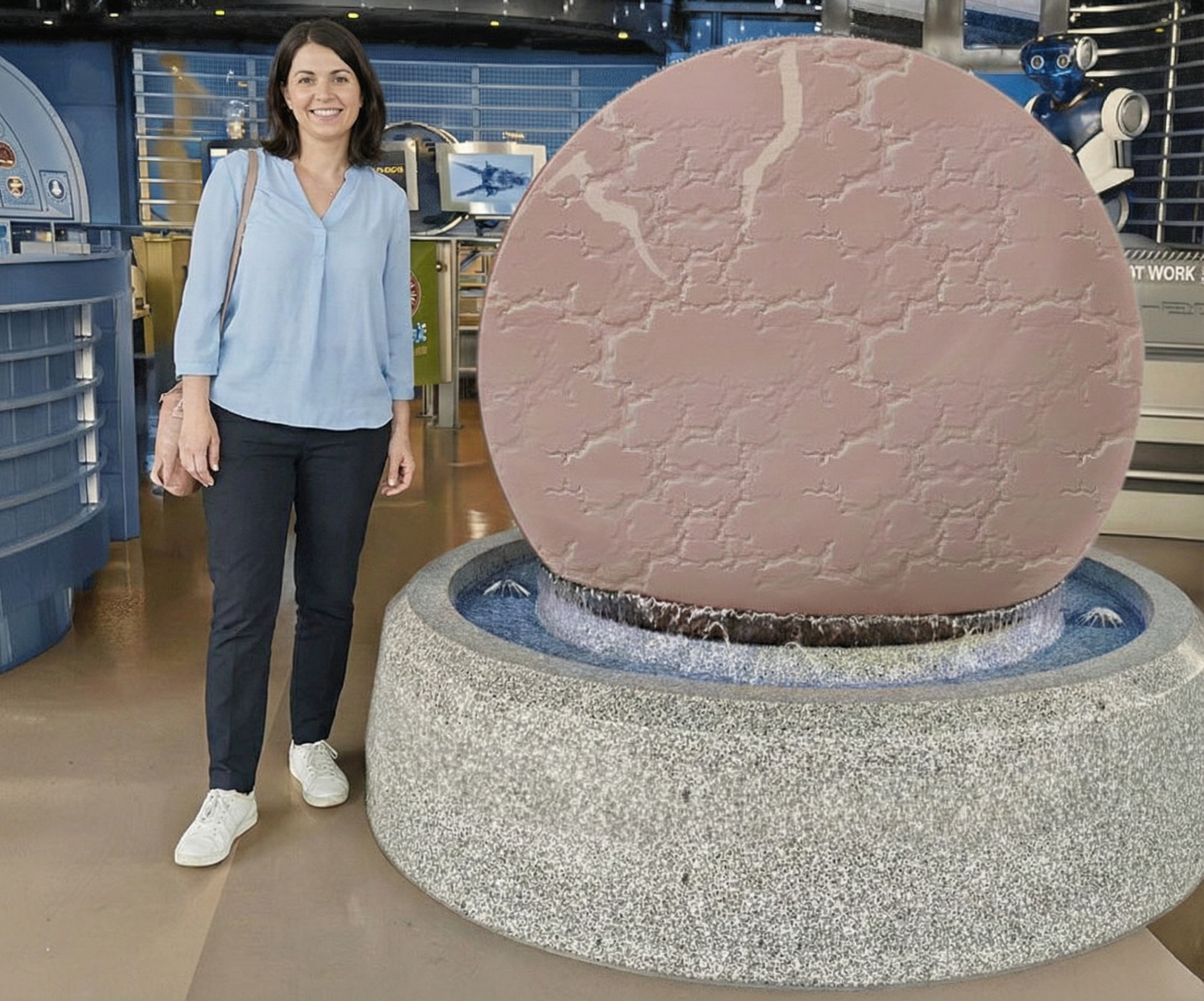 Person neben Kugel aus Granit bei einer Ausstellung