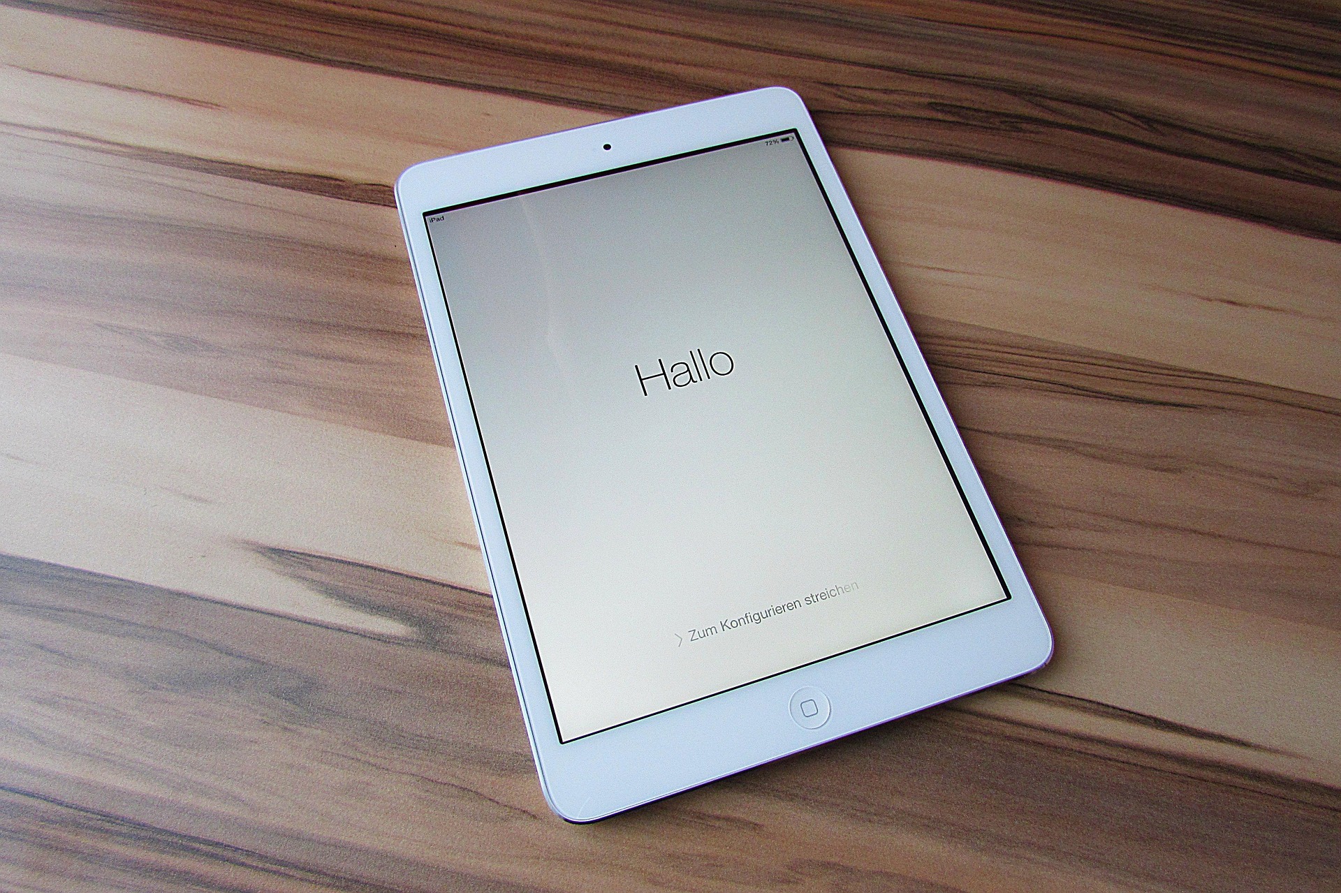 iPad mit Begrüßungsbildschirm auf Holztisch