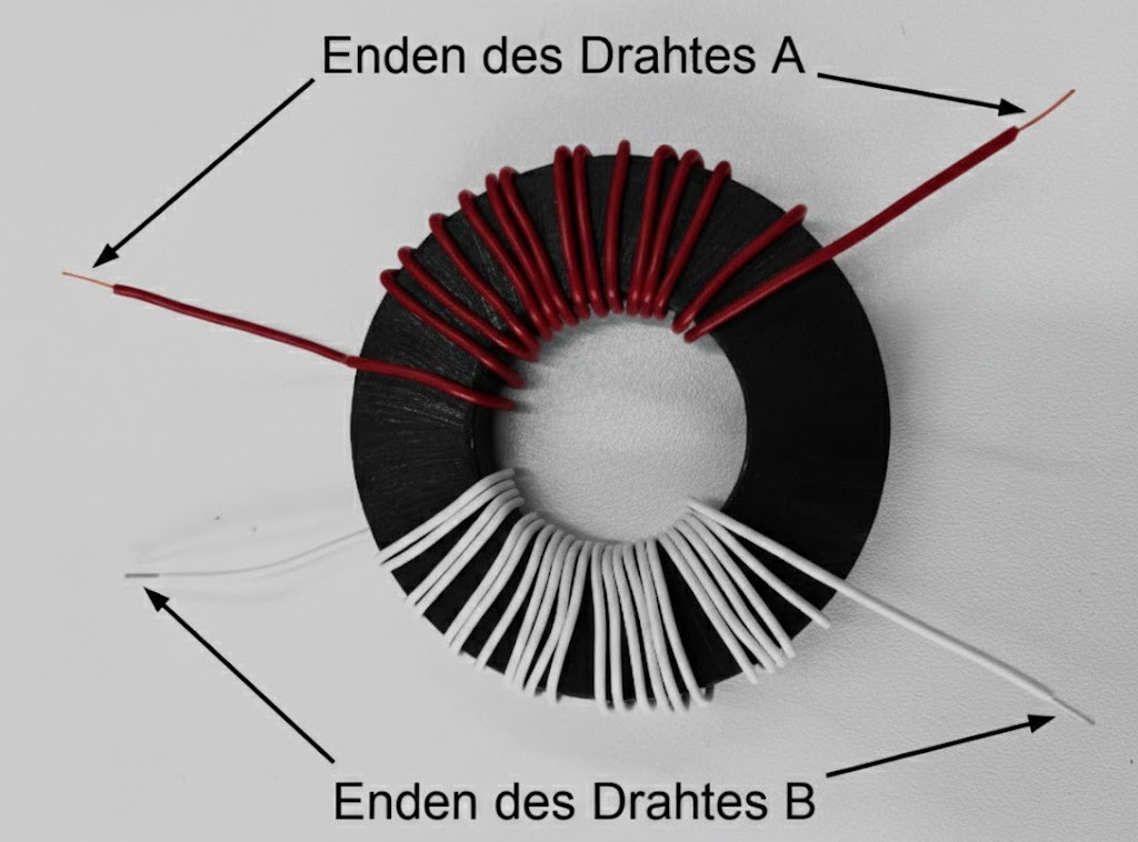 Toroidkern mit rot und weiß gewickelten Drähten, Pfeile und Beschriftung "Enden des Drahtes A/B".