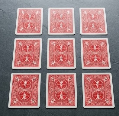 Neun rote Spielkarten mit der Rückseite nach oben in einem 3x3-Layout.