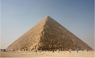 Eine große Pyramide mit Menschen im Vordergrund und klarem Himmel im Hintergrund.