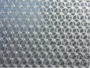 Transparente Luftpolsterfolie mit vielen kleinen Blasen in gleichmäßigem Muster.