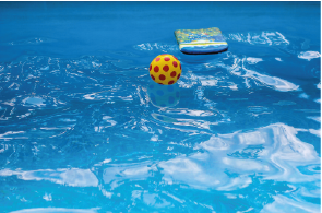 Bunte Wasseroberfläche mit einem Schwimmkörper und einem Ball in einem Pool.
