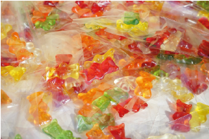 Bunte Gummibärchen in verschiedenen Farben und Formen auf einem Tisch.